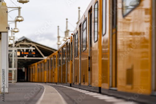 blurred close up of a yellow metro in a train station with a blurred background  