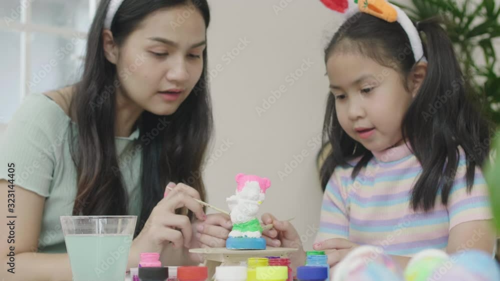 Sister and sister Have fun colouring plaster To decorate for the occasion of celebration Thanksgiving Day. Easter Day Concept. Sister and sister Have fun colouring plaster To decorate for the occasion of celebration Thanksgiving Day. Easter Day Concept.