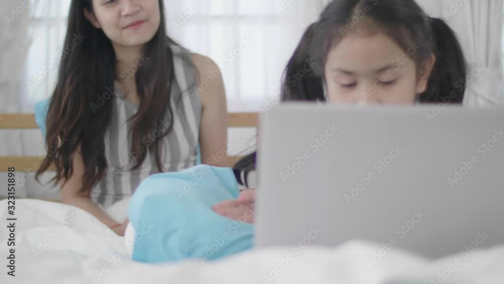Asian girls and sisters are using laptops, computers and tablets to connect to the cyber world. The little girl rested at home using the internet. Asian girls and sisters are using laptops, computers and tablets to connect to the cyber world. The little girl rested at home using the internet.