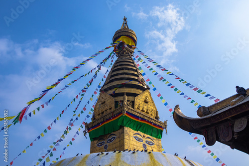 Swayambhunath, also known as Monkey Temple is located in Kathmandu, Nepal, showing it's wisdom eyes under the clear blue sky