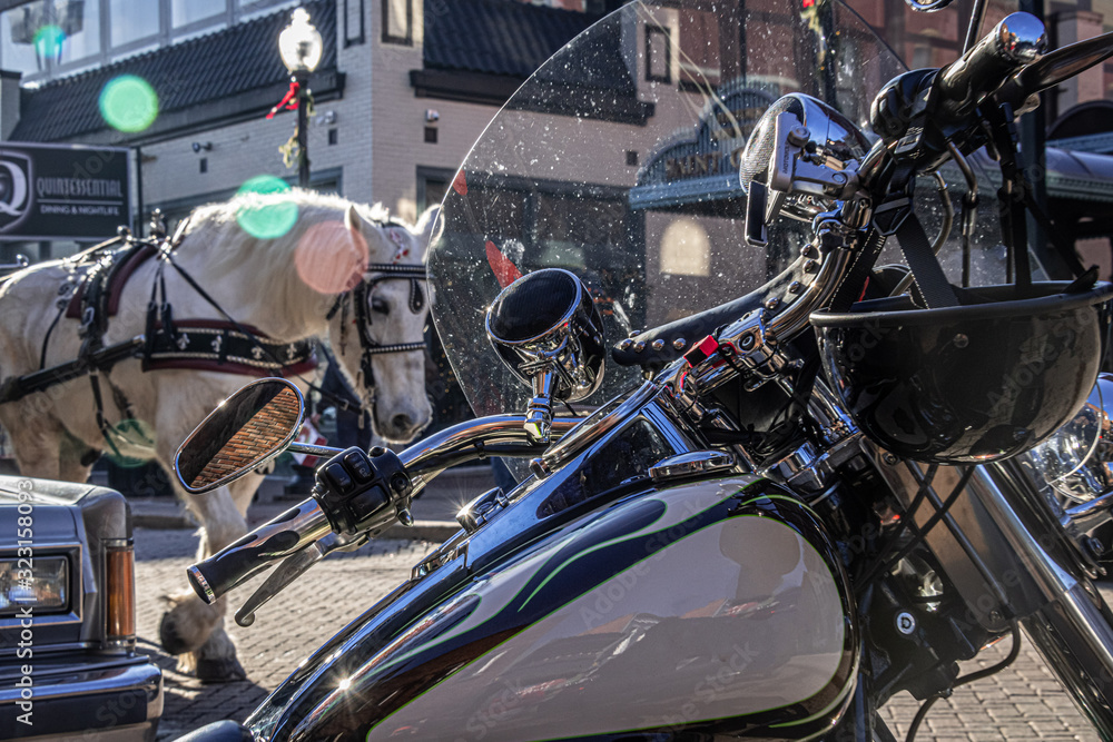 Obraz premium An old live horse and a new iron horse share the road