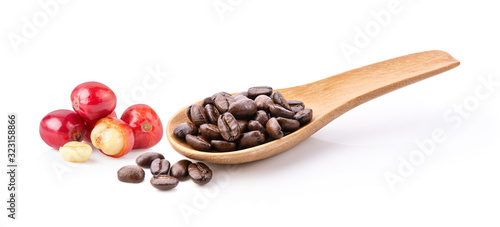 roasted coffee beans in wood spoon isolated on white background © supamas