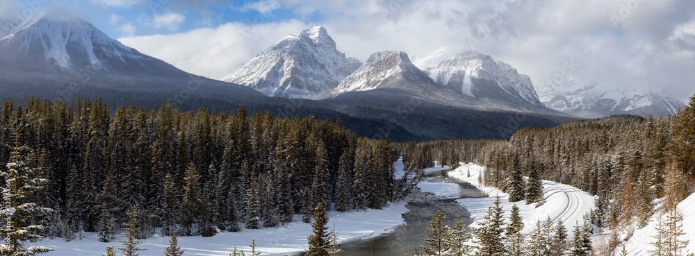 Banff National Park, Alberta, Canada. Iconic View of Morant's Curve with Canadian Rocky Mountains in the background during a vibrant winter day.