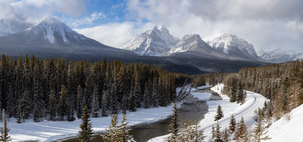 Banff National Park, Alberta, Canada. Iconic View of Morant's Curve with Canadian Rocky Mountains in the background during a vibrant winter day.