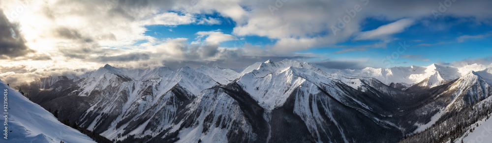 Kicking Horse, Golden, British Columbia, Canada. Beautiful Aerial Panoramic View of Canadian Mountain Landscape during a vibrant sunny and cloudy morning sunrise in winter.