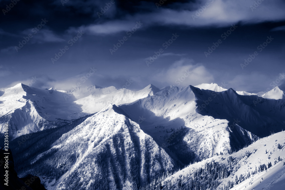 Kicking Horse, Golden, British Columbia, Canada. Beautiful Aerial View of Canadian Mountain Landscape during a vibrant sunny and cloudy morning sunrise in winter.