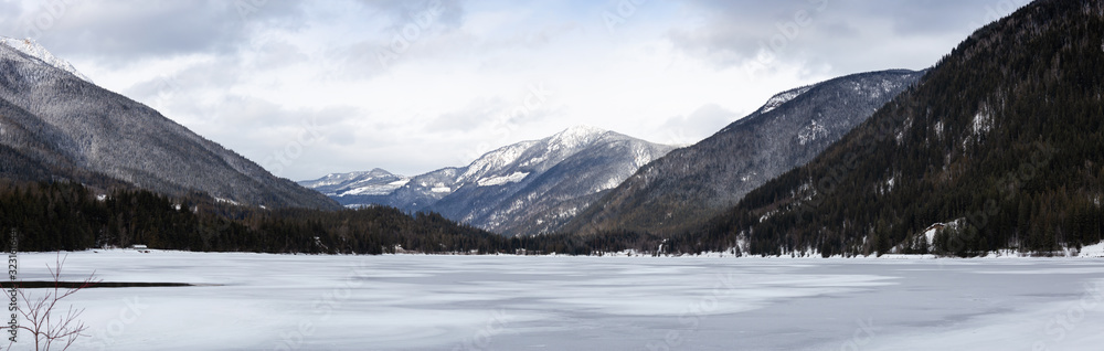 Three Valley Lake, near Revelstoke, British Columbia, Canada. Beautiful panoramic Canadian Landscape View of Frozen water and mountains in winter.