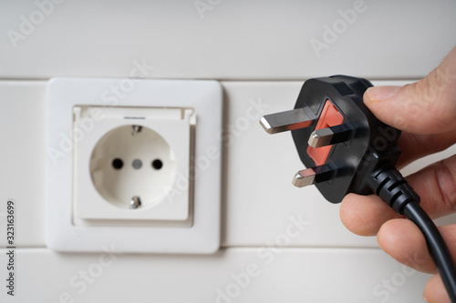 Hand Holding Incompatible AC Plug