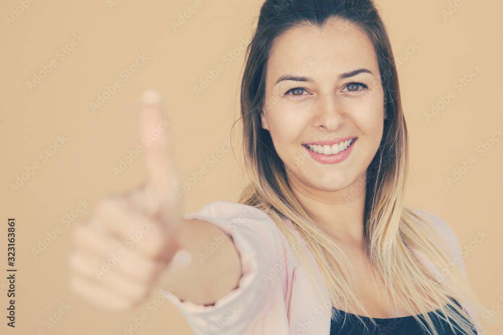 Happy satisfied customer making like gesture and recommending shop or product. Young woman in casual showing thumb up and smiling at camera. Positive review concept Happy satisfied customer making like gesture and recommending shop or product. Young woman in casual showing thumb up and smiling at camera. Positive review concept