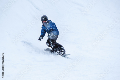 People are having fun in downhill skiing and snowboarding in the middle of snowfall  © Yan