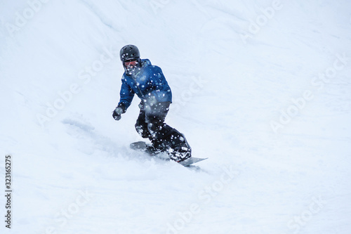 People are having fun in downhill skiing and snowboarding in the middle of snowfall 