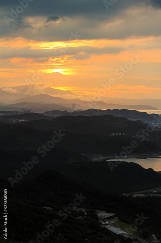 Evening sunset twilight and sun flare view at mountain slope with island sea and cloudy sky background landscape