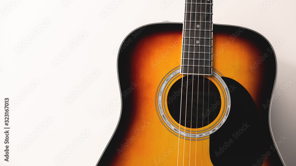 Close-up acoustic guitar on white wall background, vintage filter. Close-up acoustic guitar on white wall background, vintage filter.