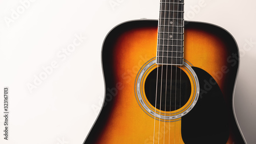 Close-up acoustic guitar on white wall background, vintage filter.