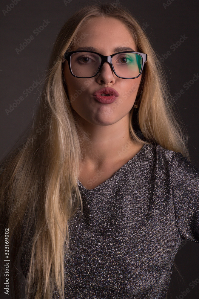Portrait of a blonde with long hair, in a gray suit, glasses Portrait of a blonde with long hair, in a gray suit, glasses