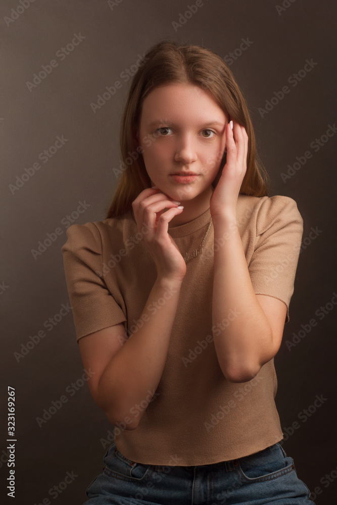 portrait of a brown-haired model in a light brown t-shirt on a brown background in the Studio portrait of a brown-haired model in a light brown t-shirt on a brown background in the Studio