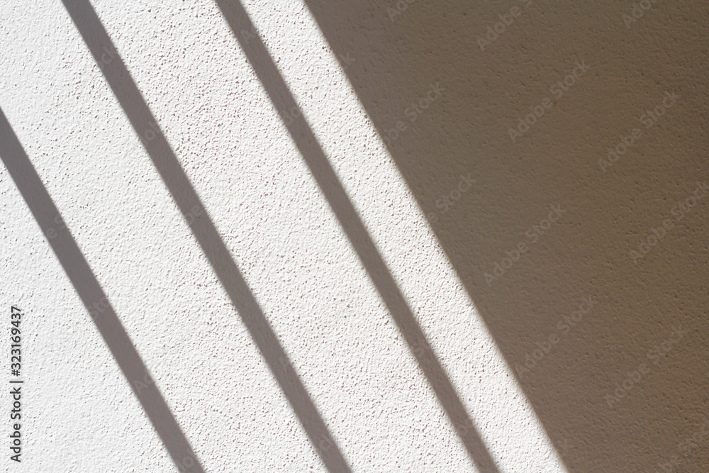 Fototapeta premium The white and gray plaster walls are rough, White and gray-white plaster surfaces, The shadow of the window on the floor of the white room in the morning.