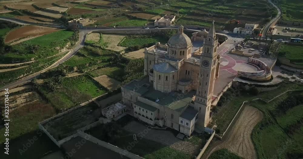 Aerial tracking shot huge church surrounded field by at sunrise Aerial tracking shot huge church surrounded field by at sunrise
