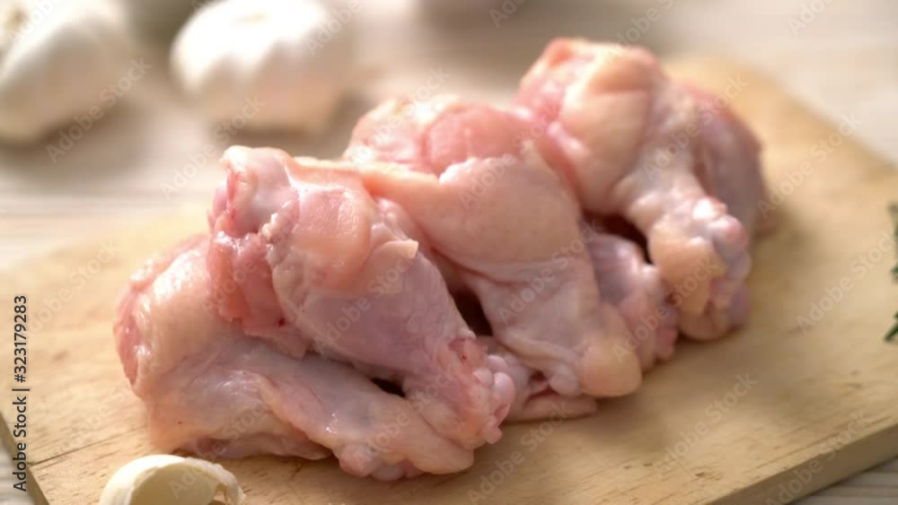 fresh raw chicken wings (drumette or drumstick) on wooden board with ingredients fresh raw chicken wings (drumette or drumstick) on wooden board with ingredients