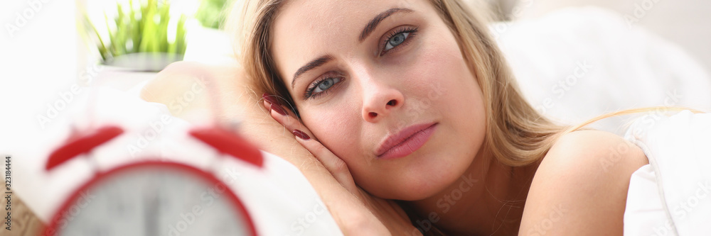 Obraz premium Young beautiful woman waking up in the morning alarm concept