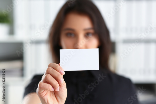 portrait of young beautiful brunette chinese businesswoman work in office show cutaway business card