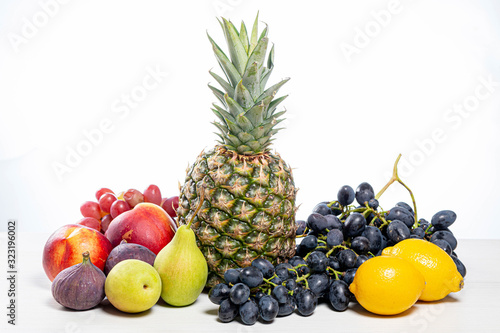 Grapes  pineapple  pears  apples  nectarine  figs and lemons on white background