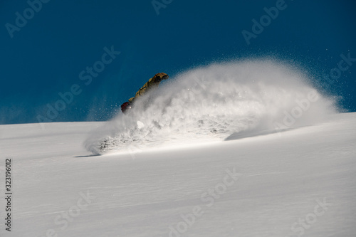 Man snowboarder glides down on the mountain side