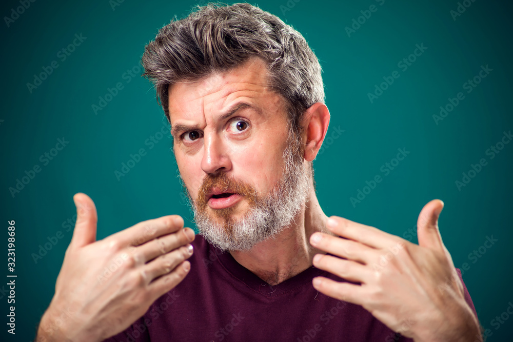 A portrait of bearded surprised man pointing fingers at himself. People and emotions concept A portrait of bearded surprised man pointing fingers at himself. People and emotions concept