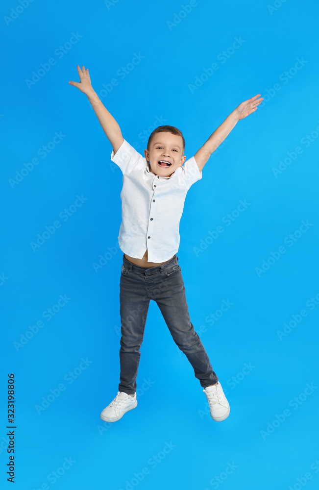 Cute little boy jumping on blue background Cute little boy jumping on blue background