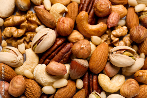Different delicious nuts as background, closeup view