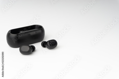 Wireless earbuds or earphones on white background. Copy space and technology concept