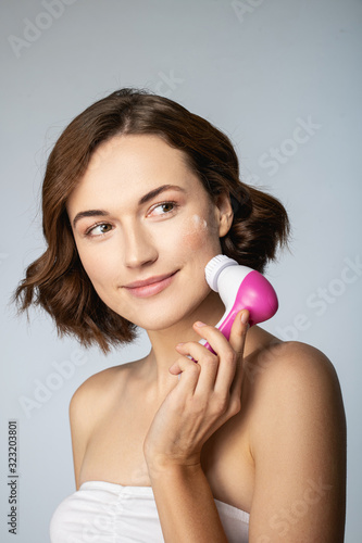 Positive delighted female person washing her face