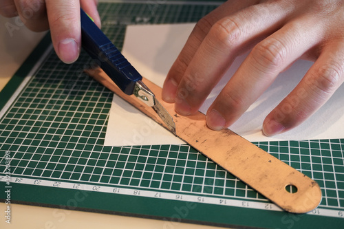 cutting paper with cutter and ruler  hands finger photo