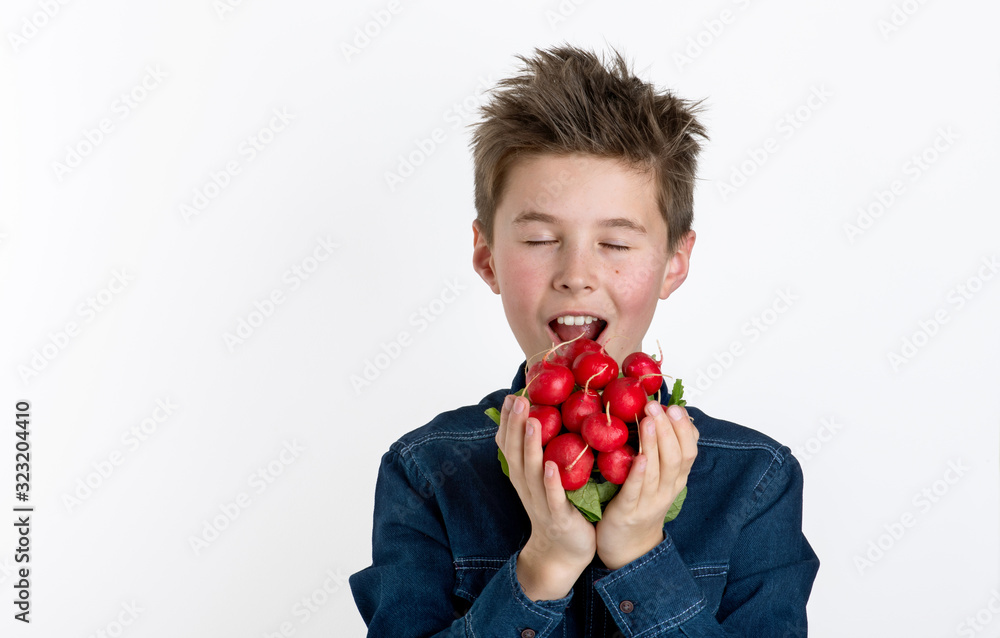 Junge genießt frische knackige Radieschen, freigestellt Hintergrund weiß Junge genießt frische knackige Radieschen, freigestellt Hintergrund weiß