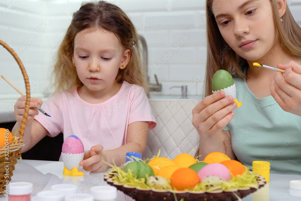 Happy easter. Two sisters painting Easter eggs. Happy family children preparing for Easter. Cute little child girl wearing bunny ears on Easter day. Happy easter. Two sisters painting Easter eggs. Happy family children preparing for Easter. Cute little child girl wearing bunny ears on Easter day.