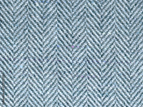 Elegant blue-gray wool fabric with zigzag stripes. Tweed suit by herringbone, texture of the background. Expensive men's suit made of fabric. High resolution