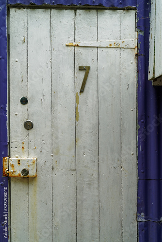 The number 7 on a rustic white shed door. photo