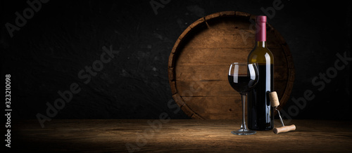Expensive wine bottles collection and wooden barrel in the cellar, wine tasting and production concept