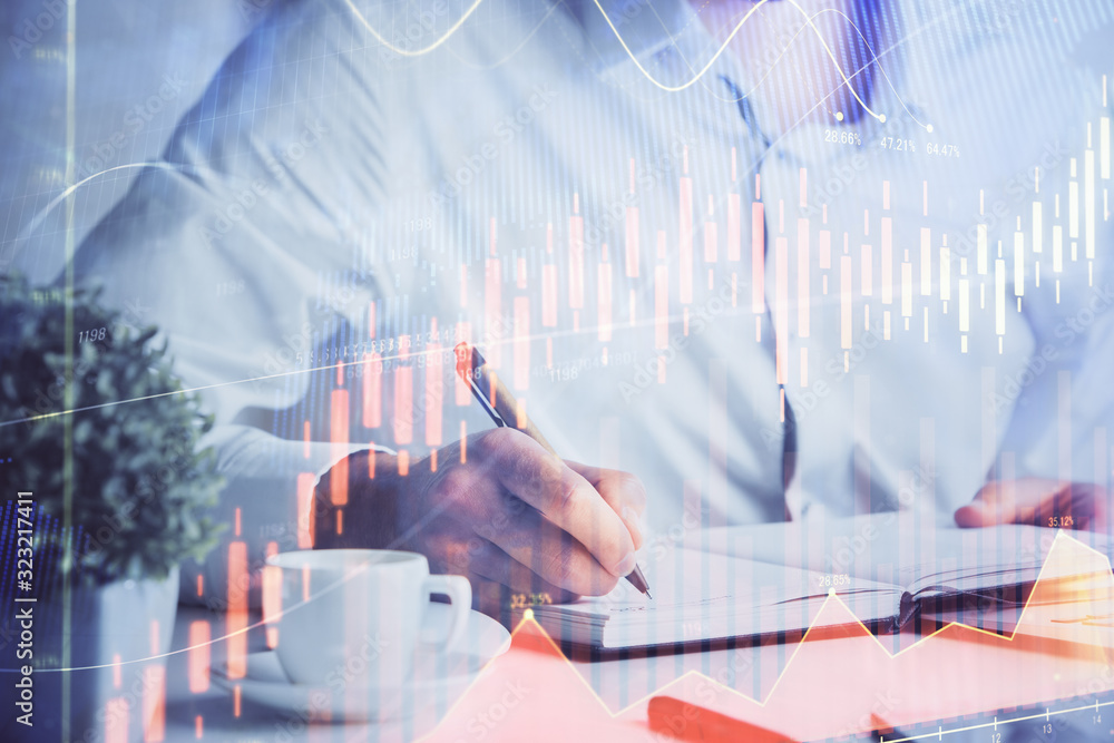 Double exposure of man's hands writing notes of stock market with forex chart. Double exposure of man's hands writing notes of stock market with forex chart.