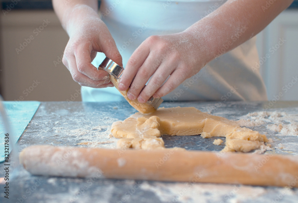 Girl making cookies with a cookie cutter Girl making cookies with a cookie cutter