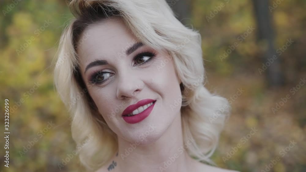 Close portrait of cute lady lightly smiles in autumn park Close portrait of cute lady lightly smiles in autumn park