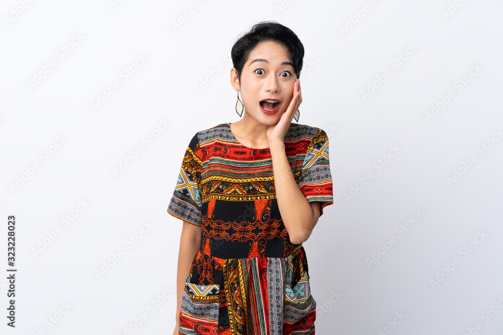 Young Asian girl with a colorful dress over isolated white background with surprise and shocked facial expression Young Asian girl with a colorful dress over isolated white background with surprise and shocked facial expression