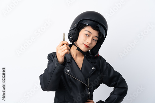 Young Asian girl with a motorcycle helmet and a key over isolated white background © luismolinero