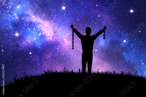 man with broken chains at night