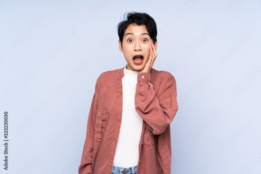 Young Asian girl over isolated blue background with surprise and shocked facial expression Young Asian girl over isolated blue background with surprise and shocked facial expression