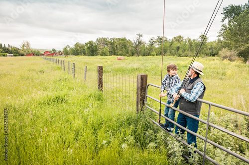 Grandfather with grandson standing on a gate going to fly fish. Red Lodge, Montana, USA photo