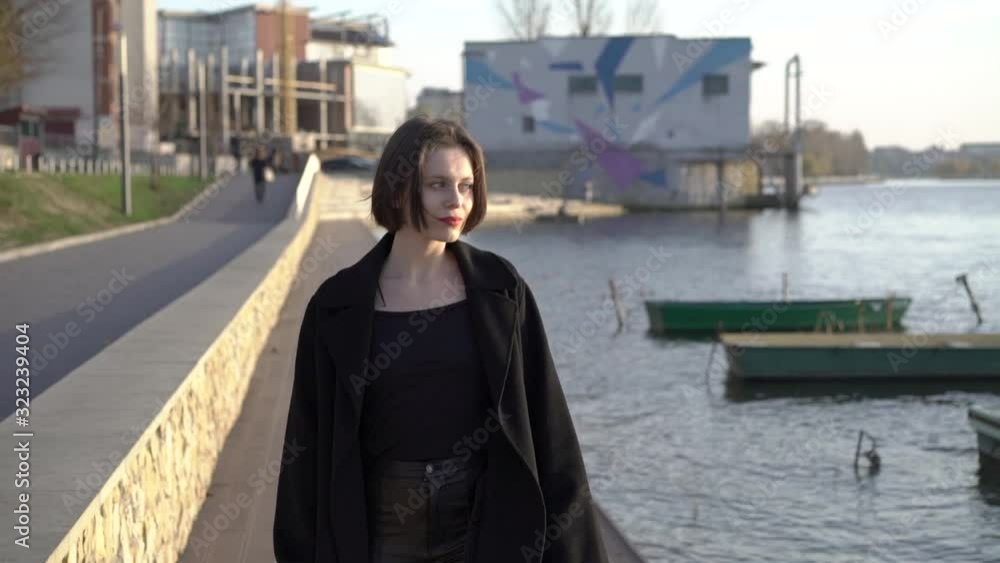 Stylish model flirts to camera, turns and walks away at the lake Stylish model flirts to camera, turns and walks away at the lake