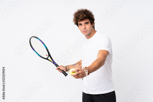 Young caucasian man over isolated white background playing tennis © luismolinero