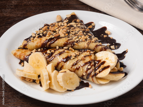 sweet pancake with banana and chocolate sauce photo