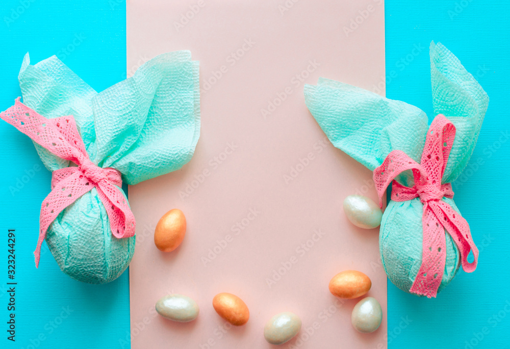 Egg gift in green paper packaging and with pink ribbon Easter Bunny wrap idea. Chocolate dragee white and gold color, Minimal concept. Flat lay, Copy space, top view Egg gift in green paper packaging and with pink ribbon Easter Bunny wrap idea. Chocolate dragee white and gold color, Minimal concept. Flat lay, Copy space, top view